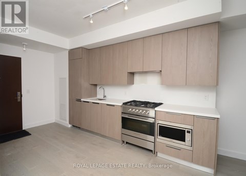 A kitchen with beige cabinets and stainless steel appliances.
