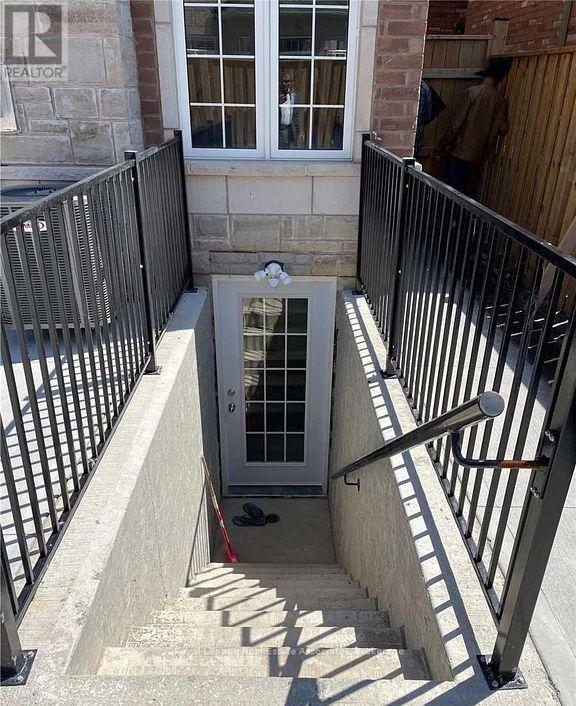 A man is standing outside a doorway with a window above it.