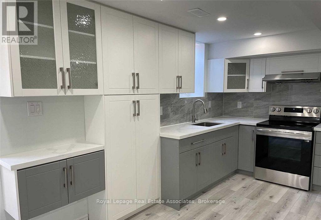 A kitchen with white cabinets and a stainless steel oven.