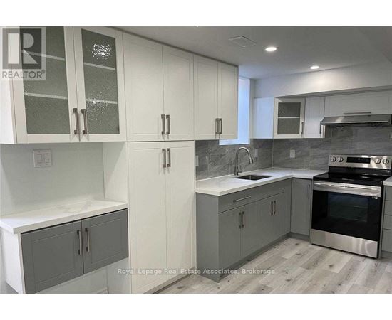 A kitchen with white cabinets and a stainless steel oven.