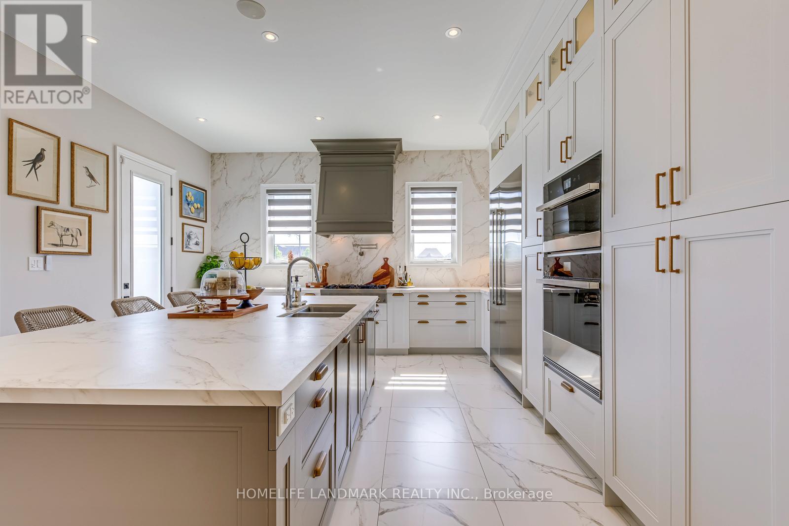 A modern kitchen with white cabinets and a marble countertop.