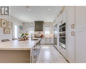 A modern kitchen with white cabinets and a marble countertop.