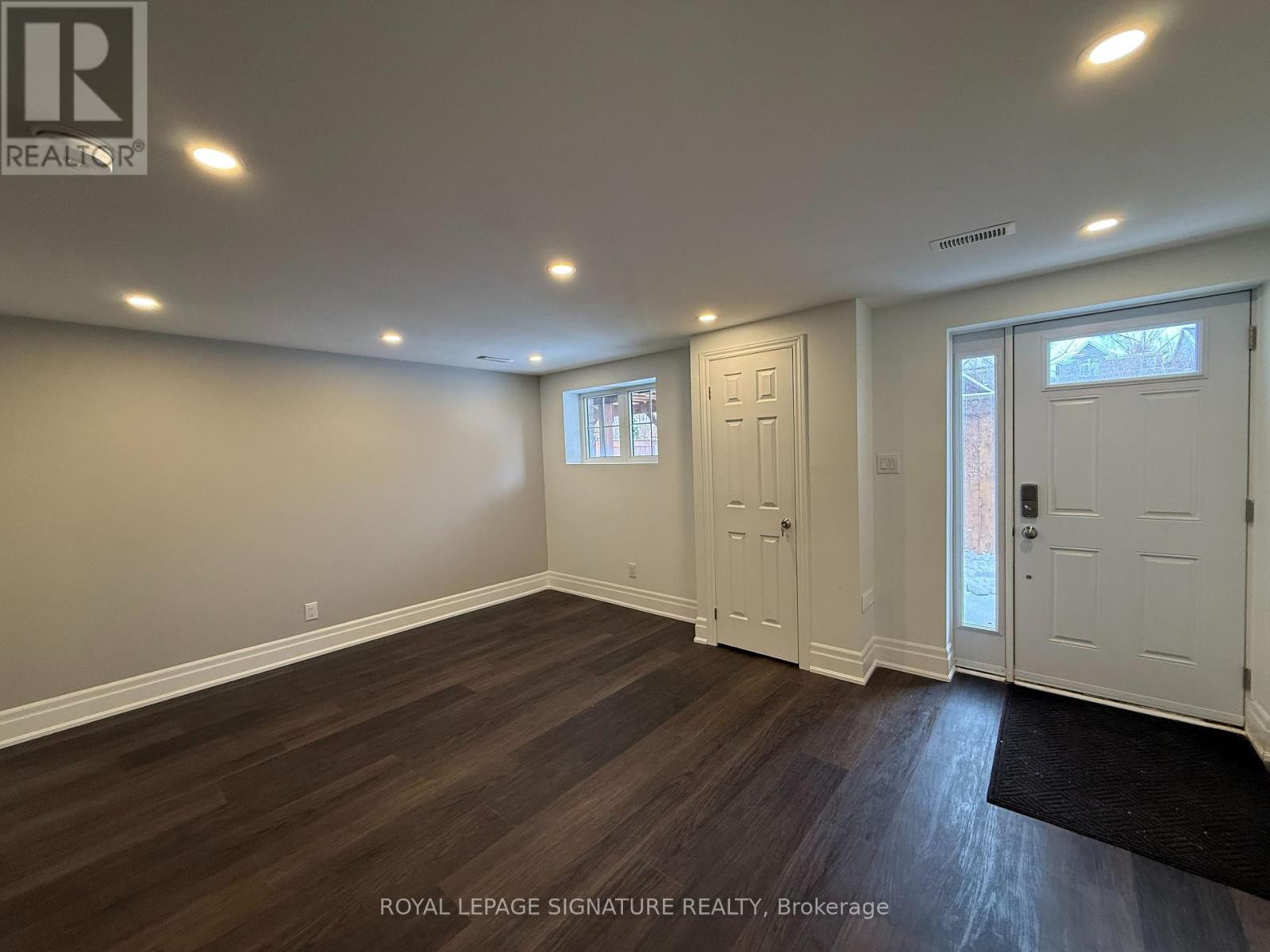 A room with wooden flooring and white walls.