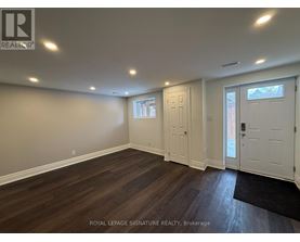 A room with wooden flooring and white walls.