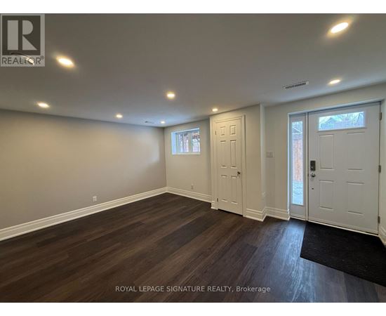 A room with wooden flooring and white walls.