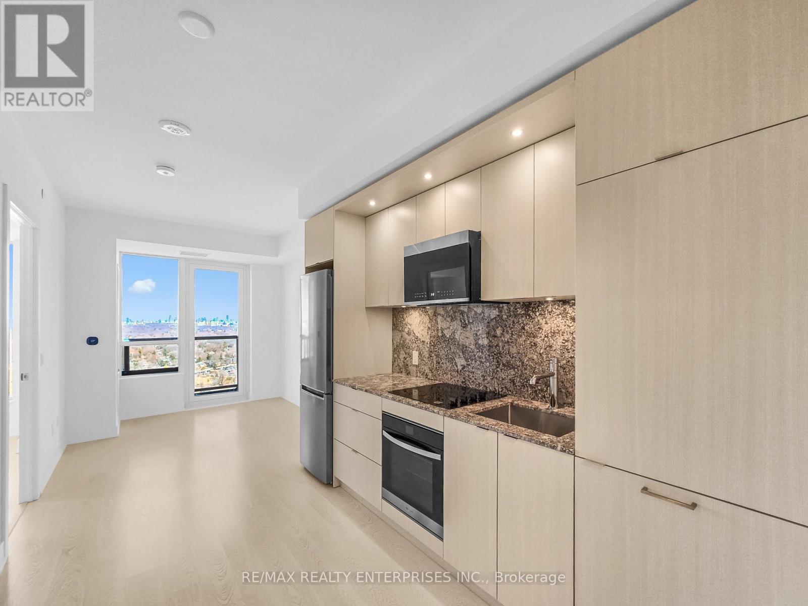 A modern kitchen with wooden cabinets and a granite countertop.