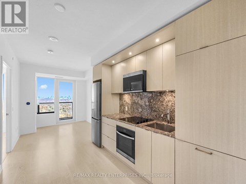 A modern kitchen with wooden cabinets and a granite countertop.