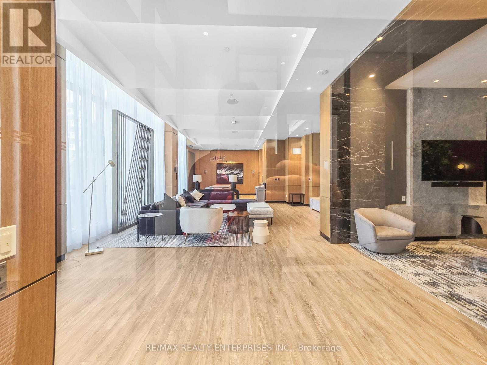 A spacious living room with a wooden floor and a large window.