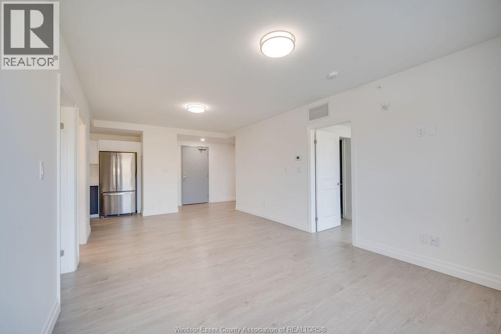 A large, empty room with a wooden floor and white walls.