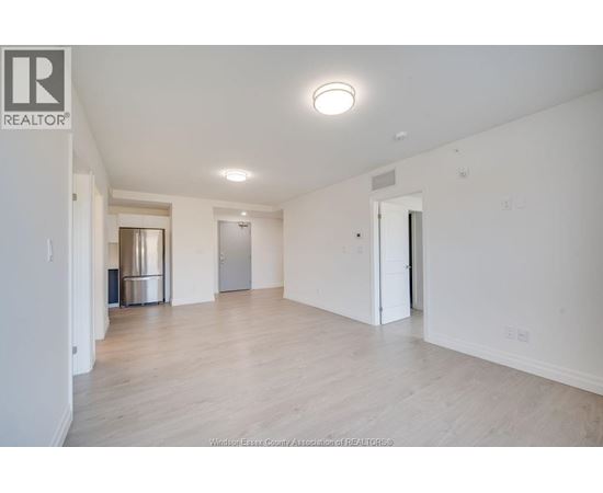A large, empty room with a wooden floor and white walls.