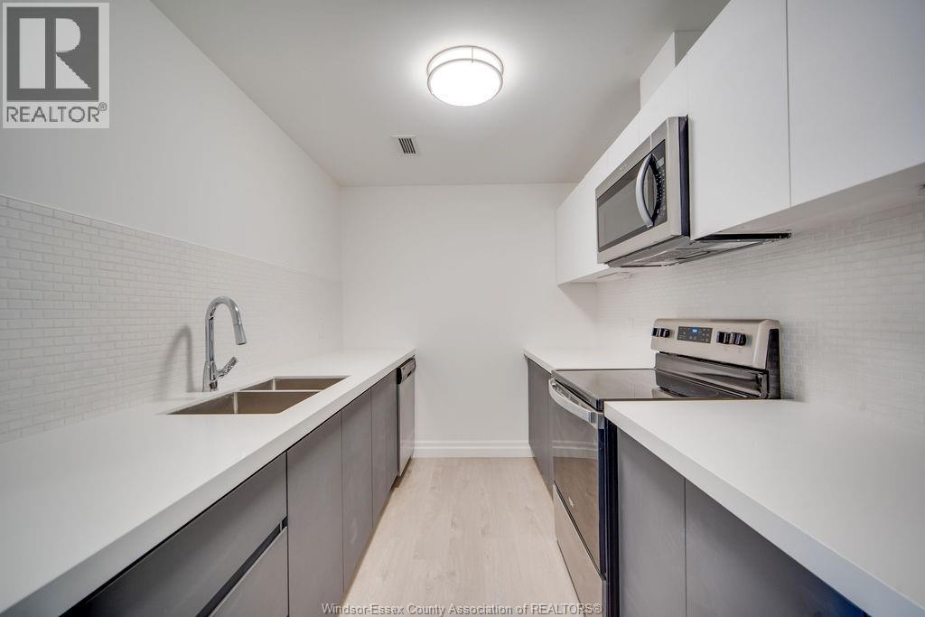 A kitchen with white cabinets and a microwave above the stove.