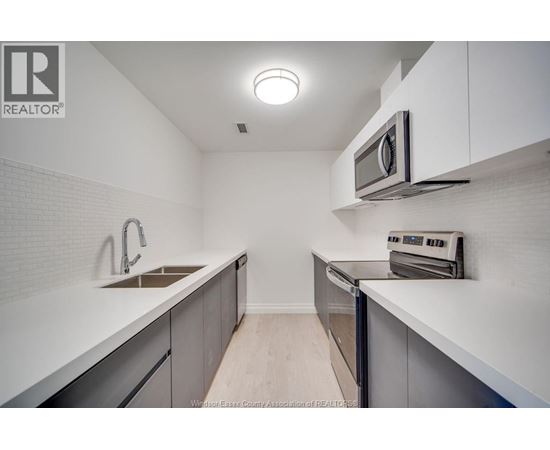 A kitchen with white cabinets and a microwave above the stove.