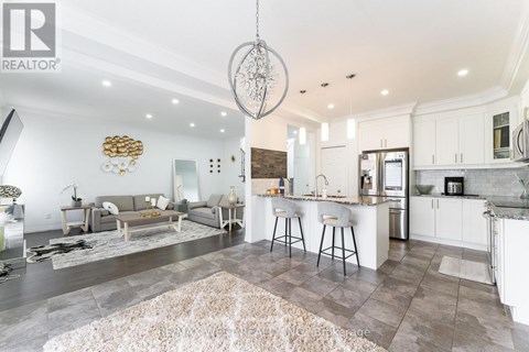 A modern kitchen and living room with a large rug on the floor.