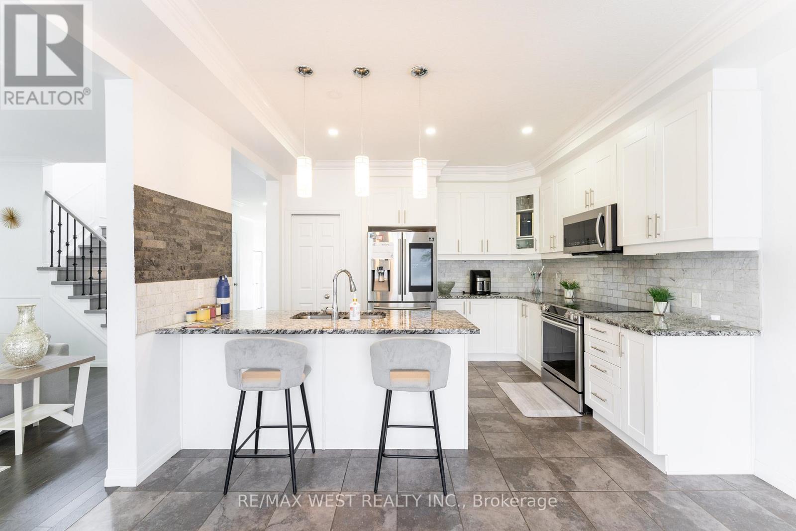 A modern kitchen with white cabinets and a marble backsplash.