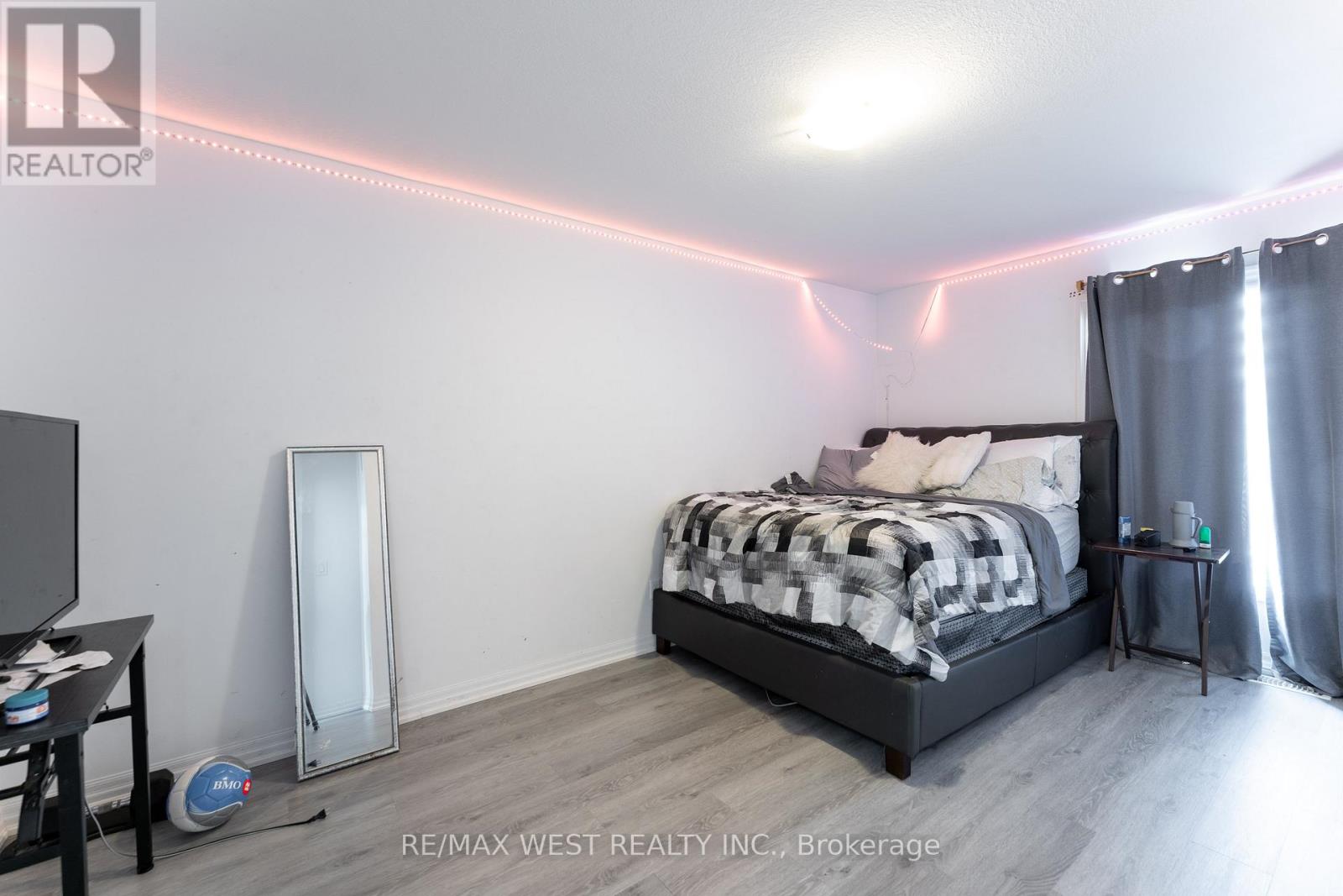 A bedroom with a bed, a chair, a small table, and a mirror.