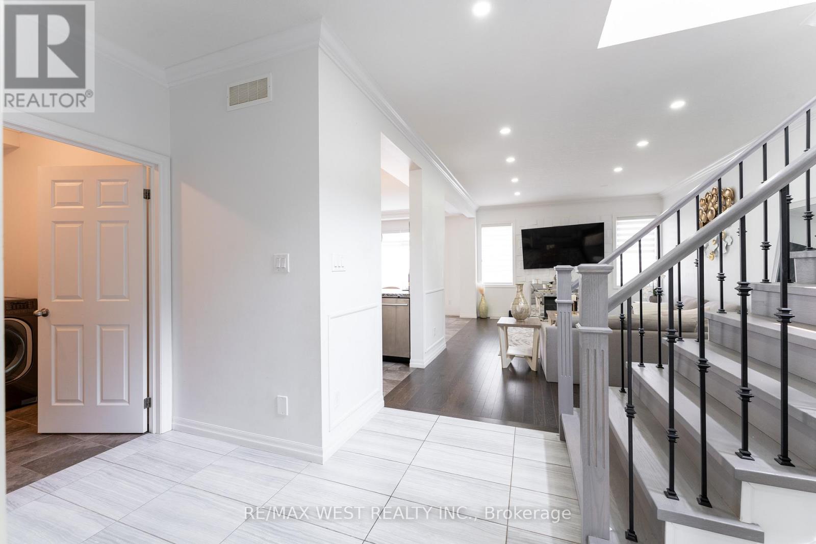 A spacious hallway with a staircase and a door leading to another room.