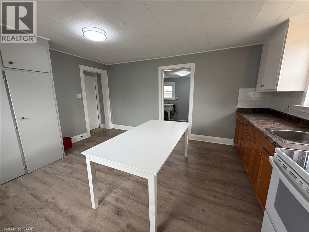A white table is in the middle of a room with a sink and cabinets.