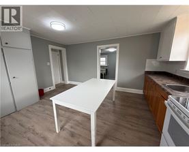 A white table is in the middle of a room with a sink and cabinets.