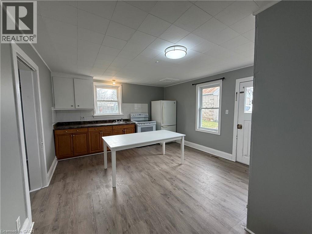 A kitchen with a table and a refrigerator.