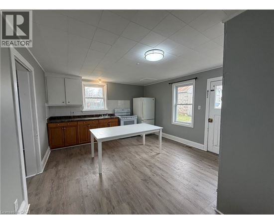 A kitchen with a table and a refrigerator.