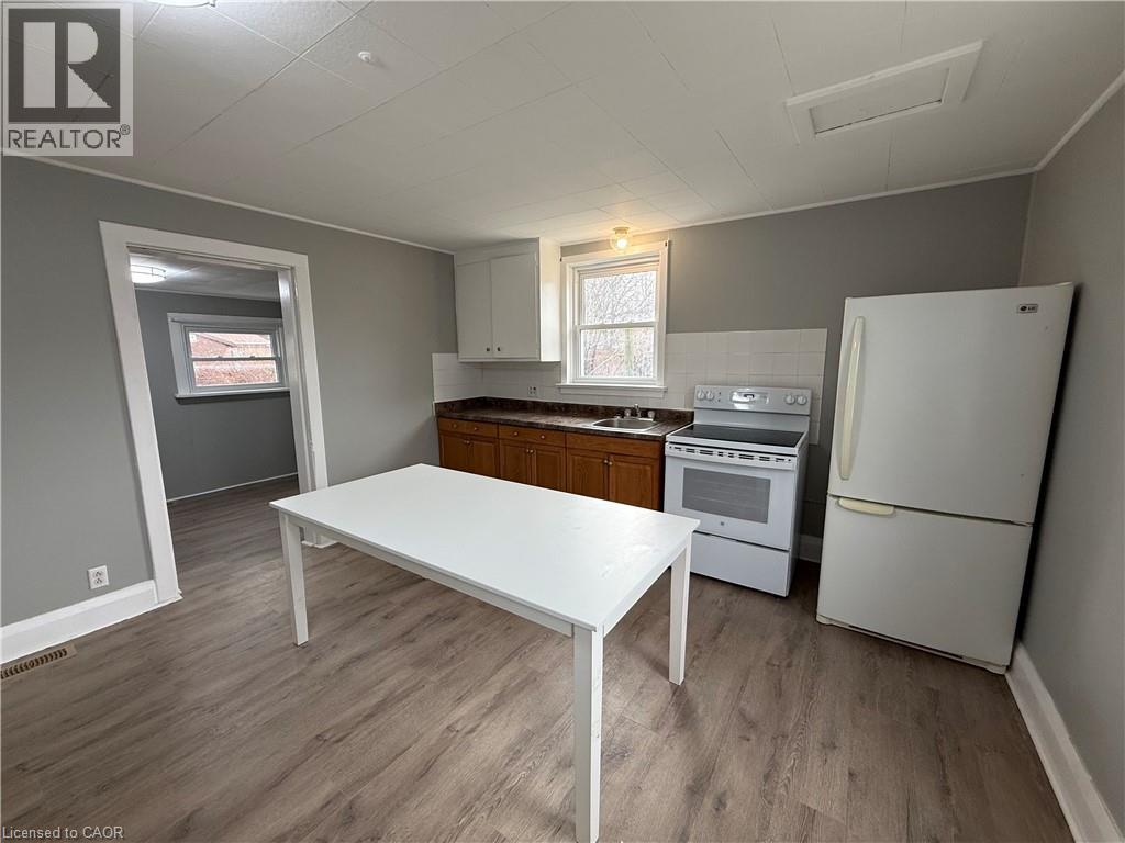 A kitchen with a white table and a white refrigerator.