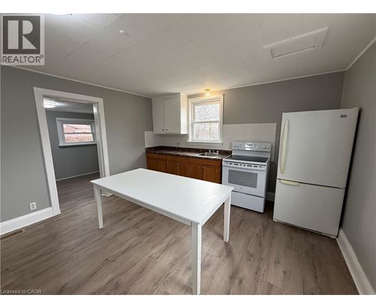 A kitchen with a white table and a white refrigerator.