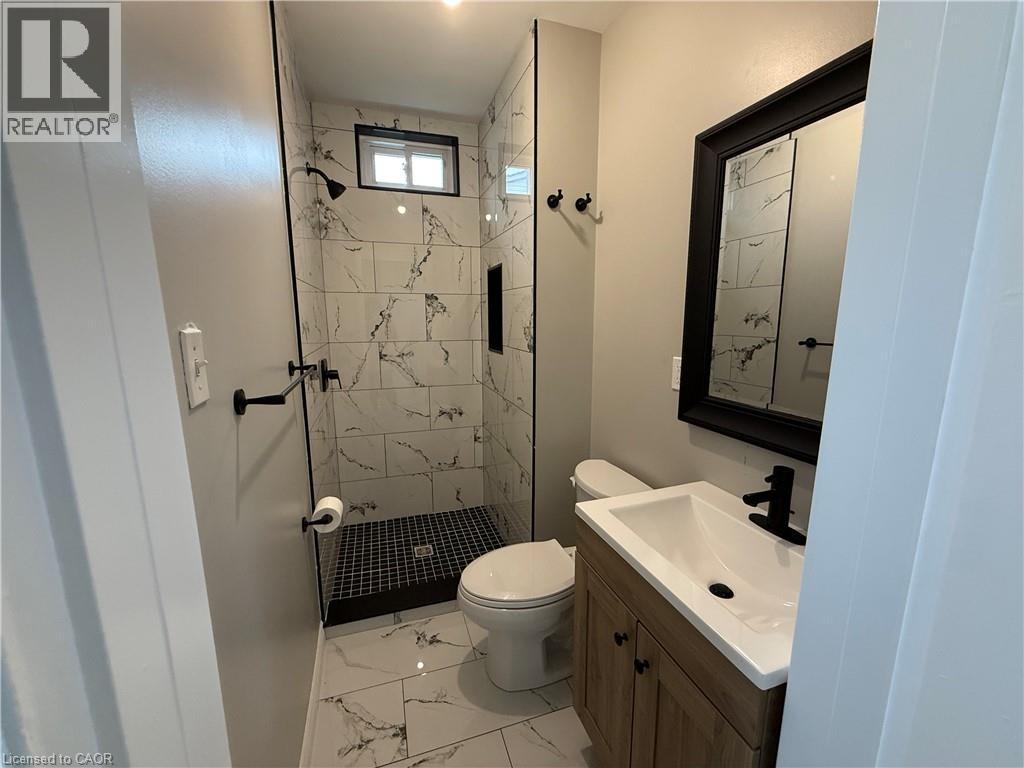A bathroom with a toilet, sink, and shower.