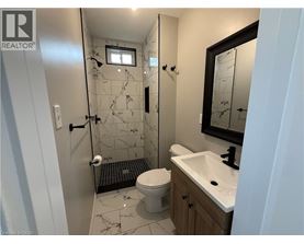 A bathroom with a toilet, sink, and shower.