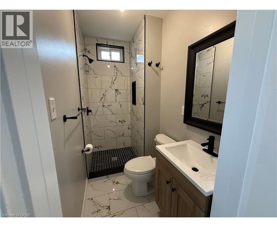 A bathroom with a toilet, sink, and shower.