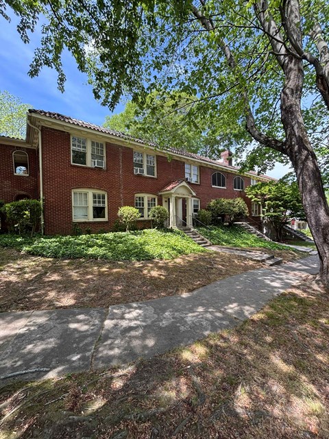 A red brick house with a white door and windows.