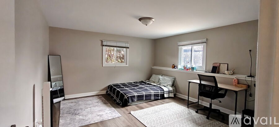 A bedroom with a bed, desk, and chair.