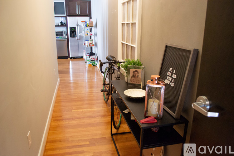 A bicycle is parked next to a table with a candle and a picture frame on it.