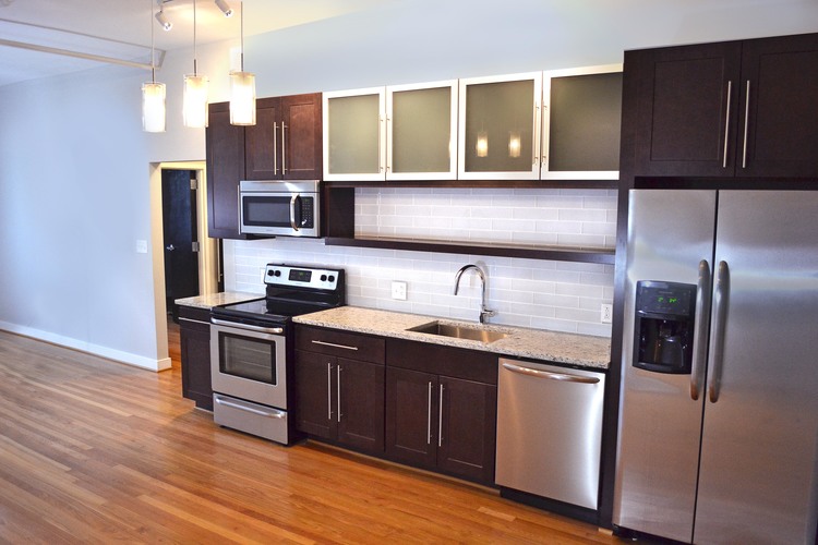 A kitchen with dark wood cabinets and stainless steel appliances.