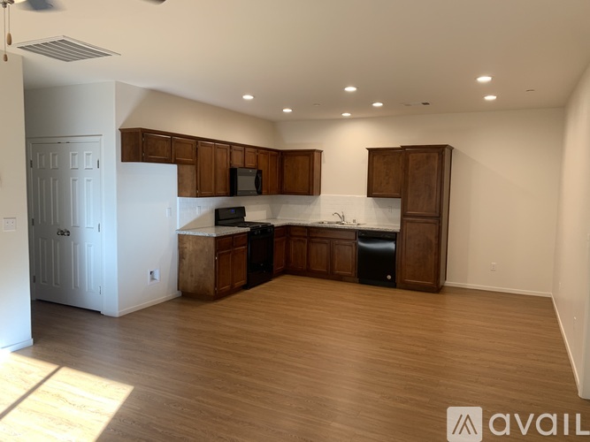 A kitchen with wooden cabinets and a white fridge is available for rent.