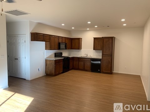 A kitchen with wooden cabinets and a white fridge is available for rent.