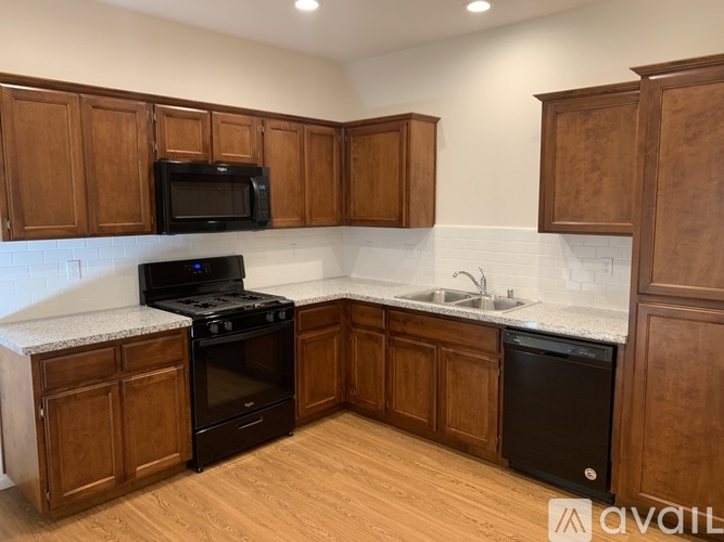 A kitchen with wooden cabinets and a black stove top oven.
