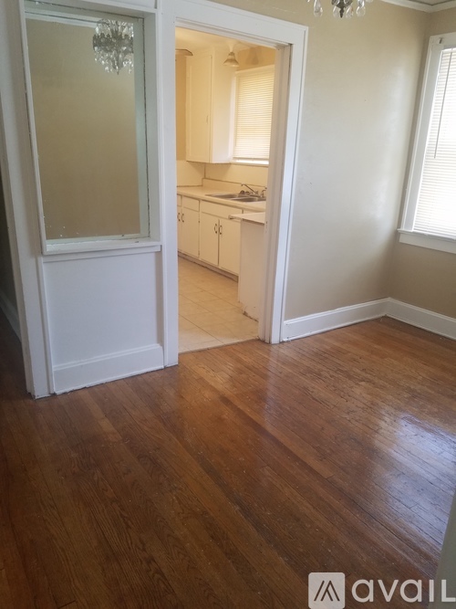 A room with wooden floors and a chandelier.