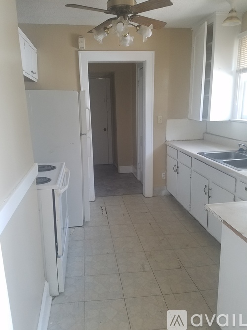 A kitchen with white appliances and cabinets.