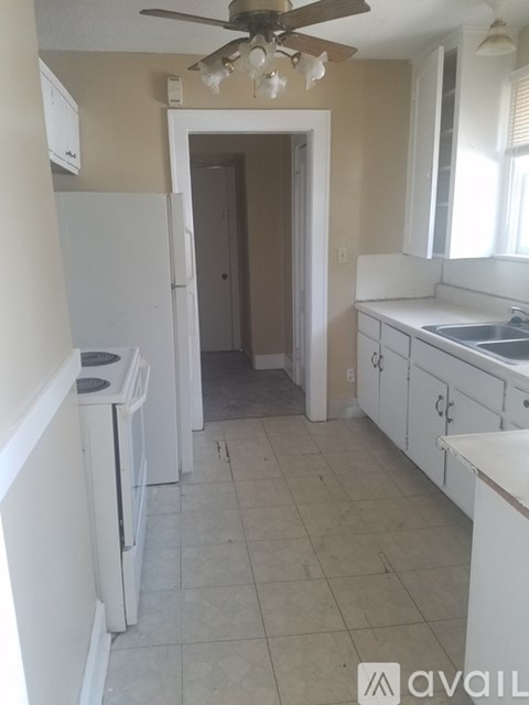 A kitchen with white appliances and cabinets.