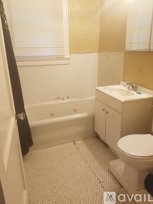 A bathroom with a white toilet, sink, and bathtub.