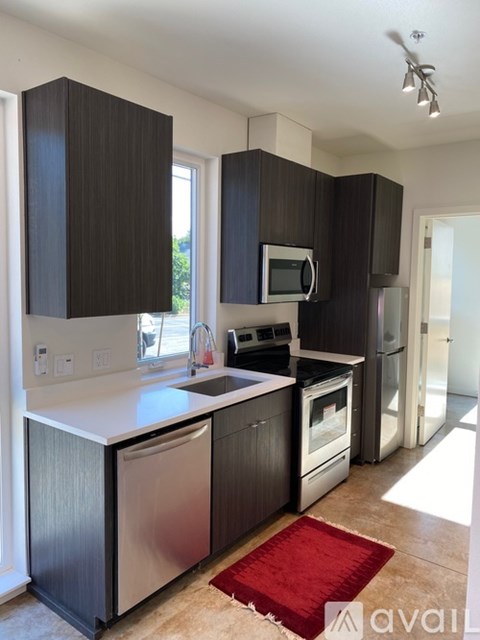 A kitchen with dark wood cabinets and stainless steel appliances.