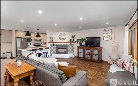 A modern living room with a grey couch and a fireplace.