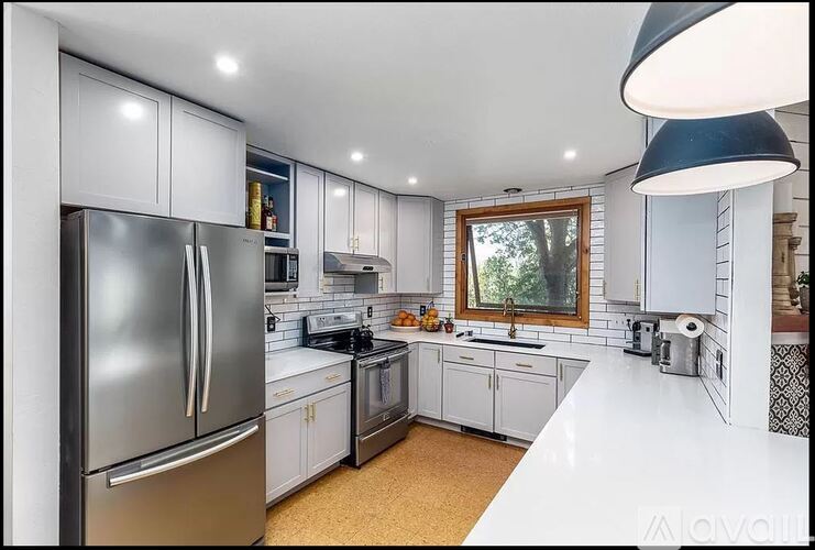 A modern kitchen with a refrigerator, oven, and sink.
