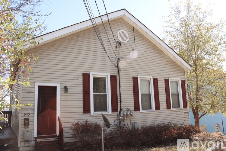 A house with a red door and a satellite dish on the roof.