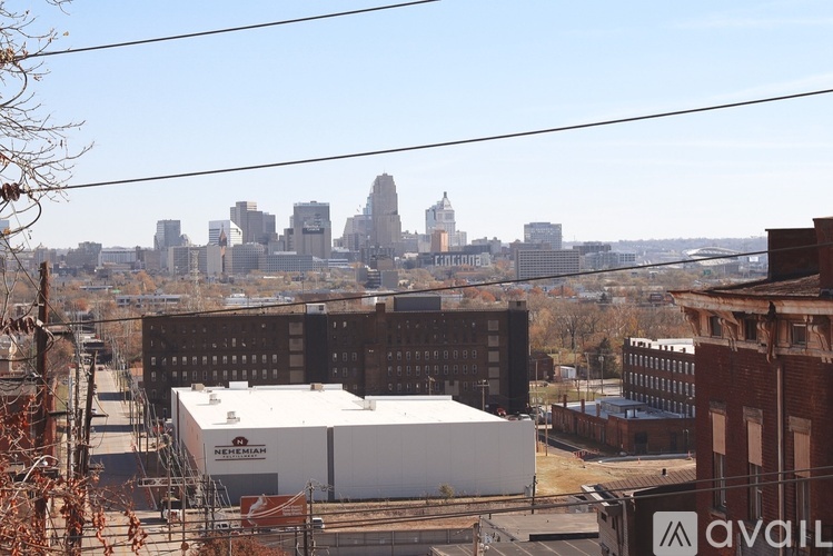 A view of a city skyline from a distance with a large white building in the foreground.