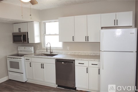 A kitchen with white cabinets and appliances.