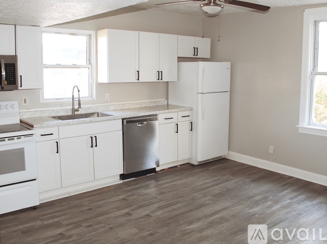 A kitchen with white appliances and cabinets.