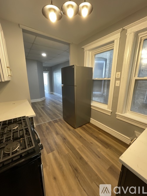 A kitchen with a black stove top oven and a refrigerator.