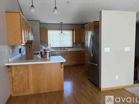 A kitchen with wooden cabinets and a refrigerator.