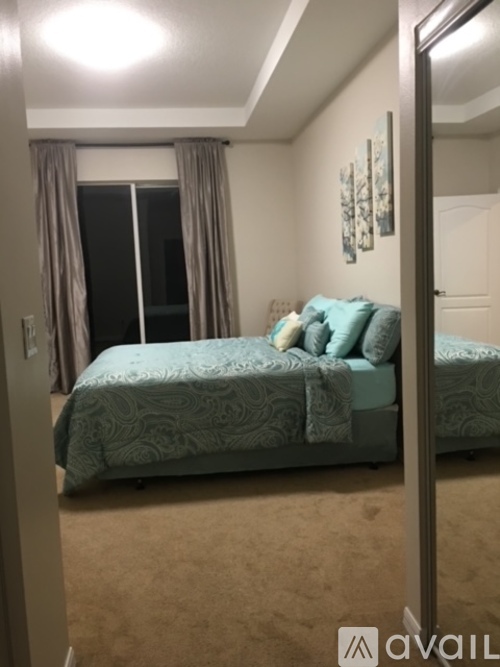 A bedroom with a bed and a window with curtains.